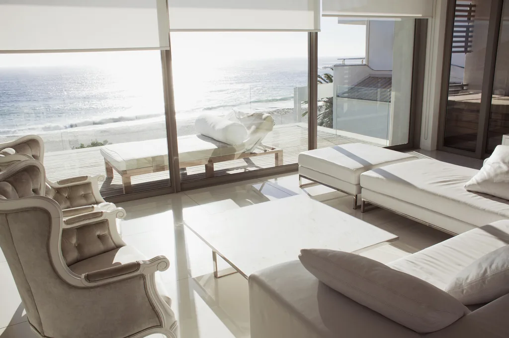 Sala com vista para o mar e tecido fechado, com a paisagem ainda visível